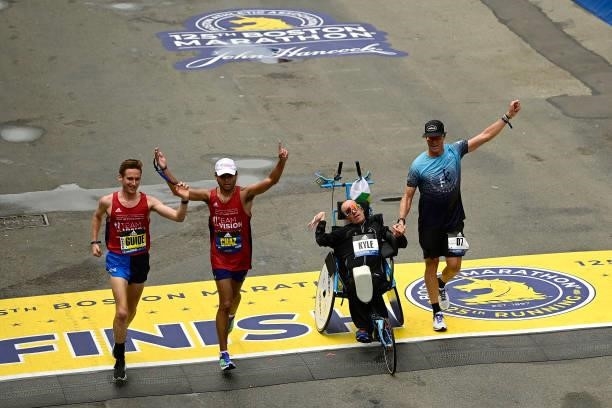 Chaz Davis of the United States reacts with his guide as he crosses the finish line to win the T11/T12 division of the 125th Boston Marathon on...