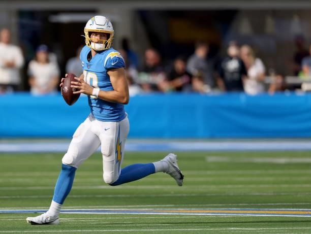 Justin Herbert of the Los Angeles Chargers rolls out of the pocket before throwing a touchdown pass during a 47-42 win over the Cleveland Browns at...