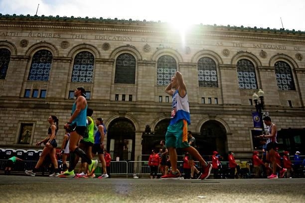 Runners react after crossing the finish line on Boylston Street during the 125th Boston Marathon on October 11, 2021 in Boston, Massachusetts.