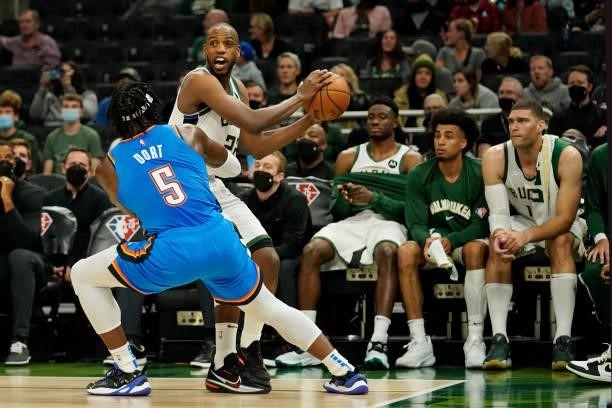 Khris Middleton of the Milwaukee Bucks looks to pass the ball against Luguentz Dort of the Oklahoma City Thunder in the first half during a preseason...