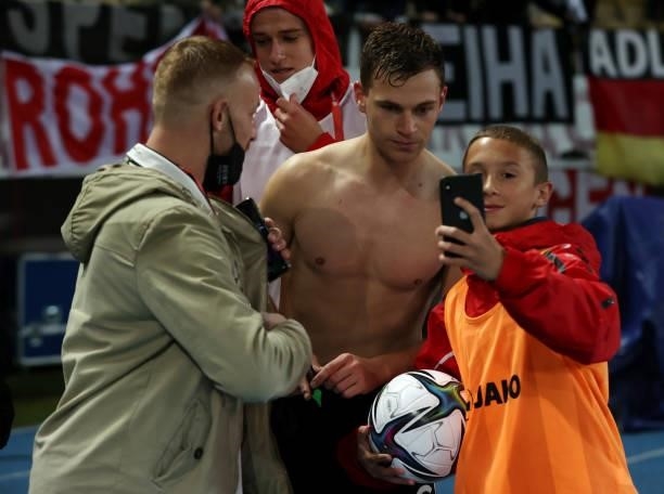 Joshua Kimmich of Germany takes a selfie with a member of the ball crew after the 2022 FIFA World Cup Qualifier match between North Macedonia and...