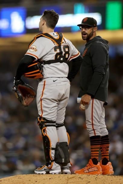 Manager Gabe Kapler and Buster Posey of the San Francisco Giants look on during a pitching change in the fifth inning of game 3 of the National...