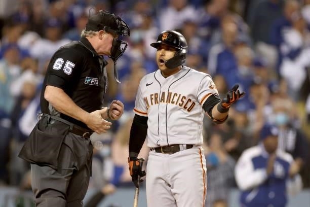 Donovan Solano of the San Francisco Giants argues a strikeout call with umpire Ted Barrett against the Los Angeles Dodgers during the eighth inning...