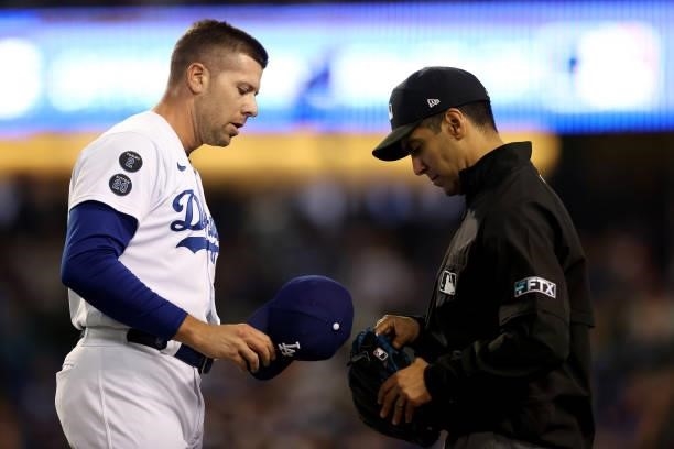 Blake Treinen of the Los Angeles Dodgers has his hat and glove inspected by umpire Gabe Morales during the eighth inning in game 3 of the National...