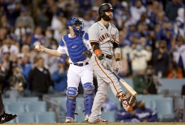 Brandon Crawford of the San Francisco Giants reacts after striking out in front of Will Smith of the Los Angeles Dodgers during the ninth inning in...