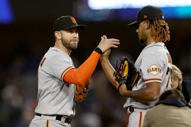 Evan Longoria and Camilo Doval of the San Francisco Giants celebrate after beating the Los Angeles Dodgers 1-0 in game 3 of the National League...