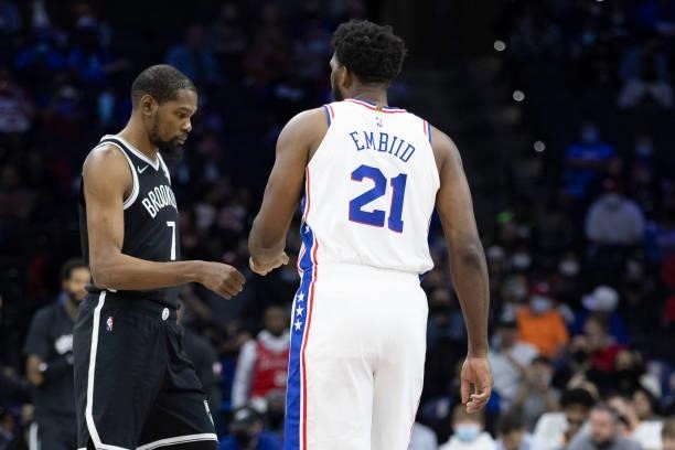 Kevin Durant of the Brooklyn Nets fist bumps Joel Embiid of the Philadelphia 76ers at the Wells Fargo Center on October 11, 2021 in Philadelphia,...