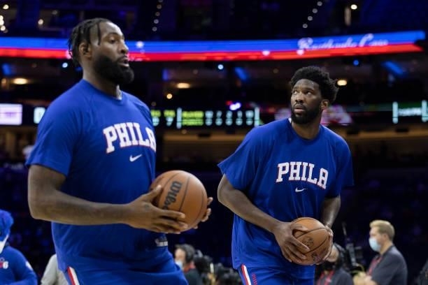 Joel Embiid and Andre Drummond of the Philadelphia 76ers warm up against the Brooklyn Nets at the Wells Fargo Center on October 11, 2021 in...