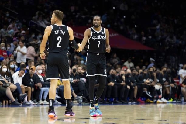 Blake Griffin and Kevin Durant of the Brooklyn Nets react against the Philadelphia 76ers at the Wells Fargo Center on October 11, 2021 in...
