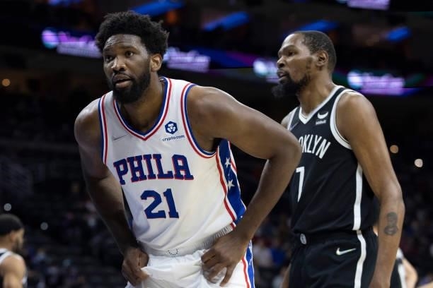 Joel Embiid of the Philadelphia 76ers reacts in front Kevin Durant of the Brooklyn Nets at the Wells Fargo Center on October 11, 2021 in...