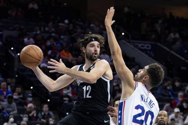 Joe Harris of the Brooklyn Nets passes the ball against Georges Niang of the Philadelphia 76ers at the Wells Fargo Center on October 11, 2021 in...