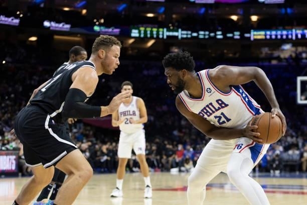 Joel Embiid of the Philadelphia 76ers controls the ball against Blake Griffin of the Brooklyn Nets at the Wells Fargo Center on October 11, 2021 in...