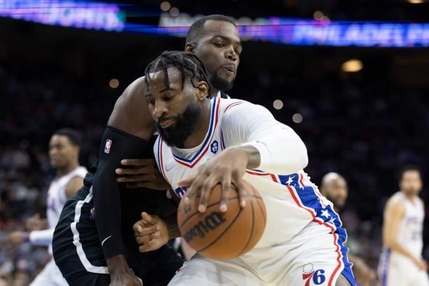 Andre Drummond of the Philadelphia 76ers drives to the basket against Paul Millsap of the Brooklyn Nets at the Wells Fargo Center on October 11, 2021...