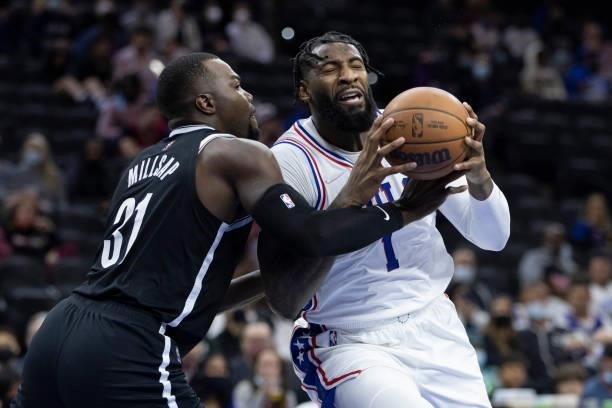 Andre Drummond of the Philadelphia 76ers drives to the basket against Paul Millsap of the Brooklyn Nets at the Wells Fargo Center on October 11, 2021...
