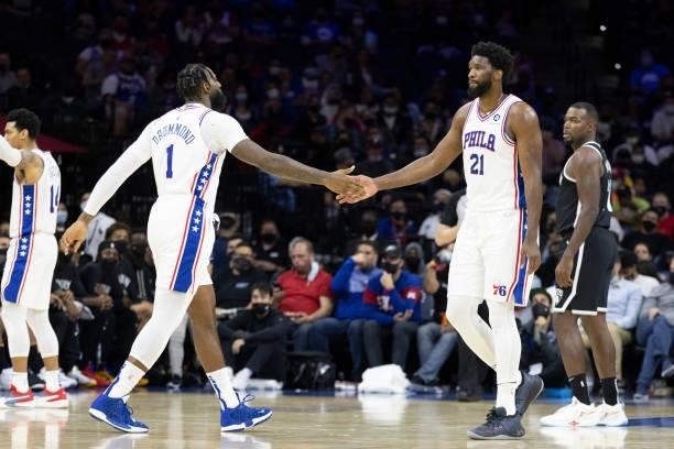 Andre Drummond and Joel Embiid of the Philadelphia 76ers react against the Brooklyn Nets at the Wells Fargo Center on October 11, 2021 in...