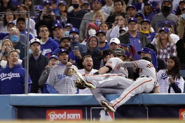 Kris Bryant and Mike Yastrzemski of the San Francisco Giants chase a foul ball by AJ Pollock of the Los Angeles Dodgers during the ninth inning in...