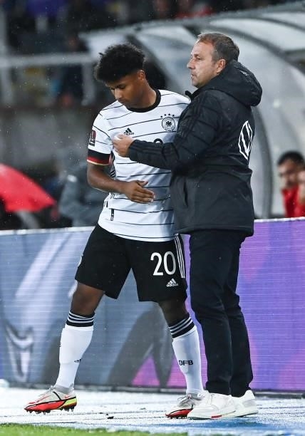 Head Coach Hans-Dieter Flick of Germany and Karim Adeyemi of Germany shake hands during the 2022 FIFA World Cup Qualifier match between North...