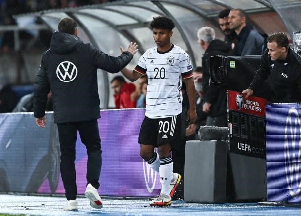 Head Coach Hans-Dieter Flick of Germany and Karim Adeyemi of Germany shake hands during the 2022 FIFA World Cup Qualifier match between North...