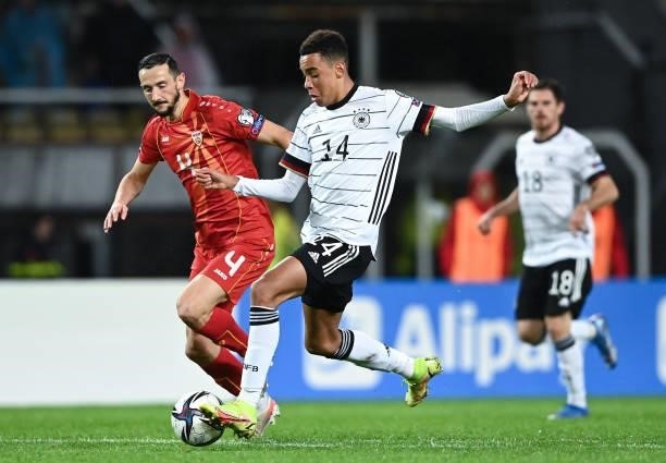Jamal Musiala of Germany challenges for the ball with Kire Ristevski of North Macedonia during the 2022 FIFA World Cup Qualifier match between North...