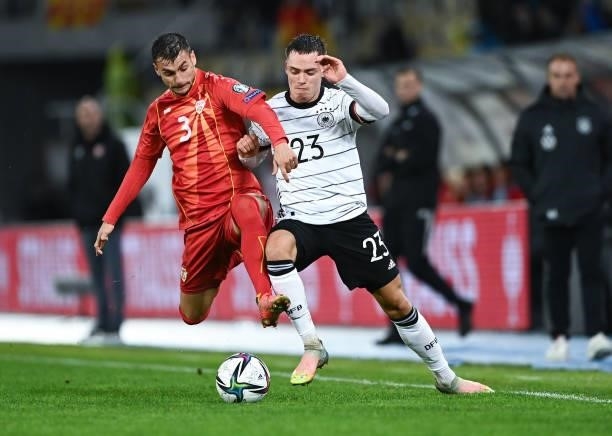 Stefan Ashkovski of North Macedonia challenges for the ball with Florian Wirtz of Germany during the 2022 FIFA World Cup Qualifier match between...