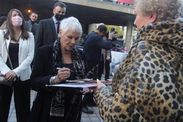 Dame Judi Dench signs an autograph at the "Belfast