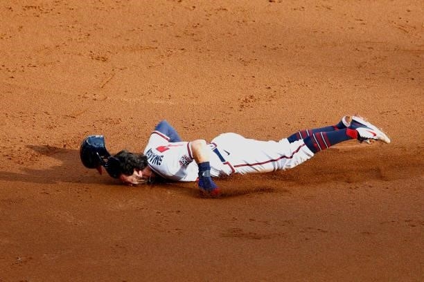 Dansby Swanson of the Atlanta Braves slides into third during the first inning against the Milwaukee Brewers in game four of the National League...