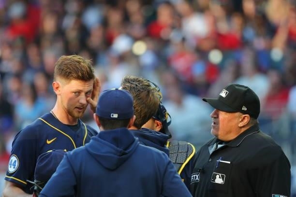 Eric Lauer of the Milwaukee Brewers is tended to by staff during the third inning in game four of the National League Division Series at Truist Park...