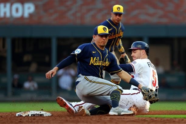 Freddie Freeman of the Atlanta Braves is safe at second ahead of Luis Urias of the Milwaukee Brewers during the third inning in game four of the...