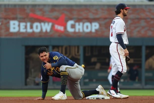 Avisail Garcia of the Milwaukee Brewers advances to second on a wild throw to first ahead of Dansby Swanson of the Atlanta Braves during the fourth...
