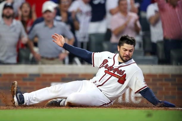 Travis d'Arnaud of the Atlanta Braves slides into score during the fourth inning against the Milwaukee Brewers in game four of the National League...