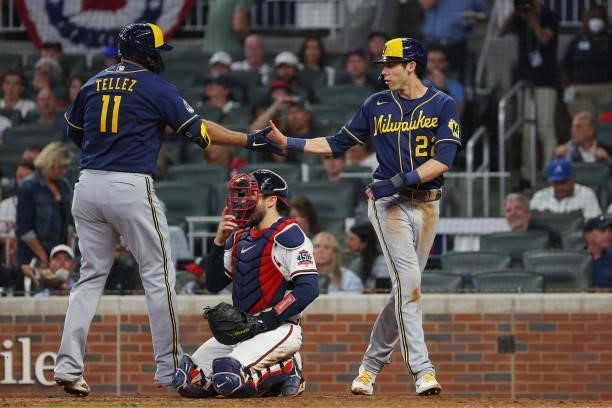 Rowdy Tellez of the Milwaukee Brewers high fives Christian Yelich of the Milwaukee Brewers after hitting a two run home run during the fifth inning...