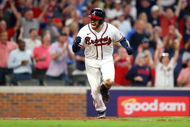 Travis d'Arnaud of the Atlanta Braves reacts to a run scored in the 5th against the Milwaukee Brewers in game four of the National League Division...