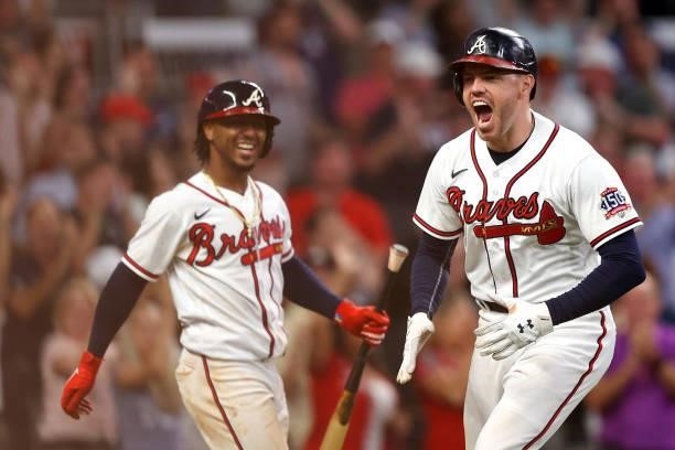Freddie Freeman of the Atlanta Braves reacts after hitting a home run during the eighth inning against the Milwaukee Brewers in game four of the...