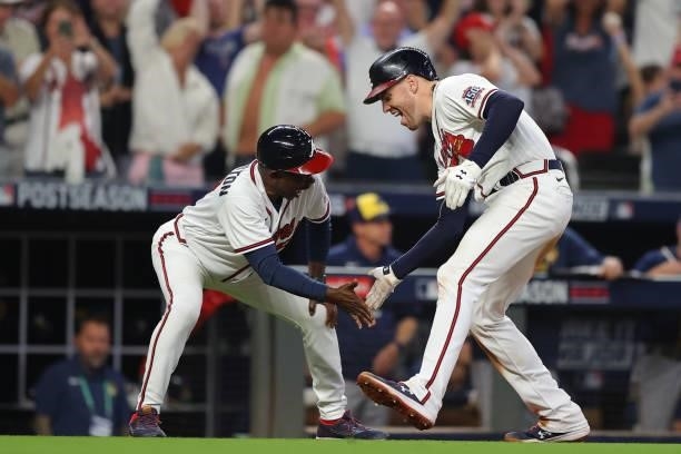 Freddie Freeman of the Atlanta Braves reacts with Ron Washington after hitting a home run during the eighth inning against the Milwaukee Brewers in...