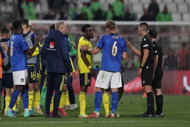 Matteo Lovato of Italy talks with Anthony Elanga of Sweden following the final whistle after the Swedish striker reacted to jeers from fans after his...