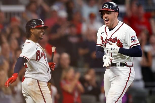Freddie Freeman of the Atlanta Braves celebrates with Ozzie Albies after hitting a home run during the eighth inning against the Milwaukee Brewers in...