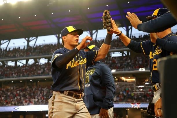Luis Urias of the Milwaukee Brewers high fives teammates during the third inning against the Atlanta Braves in game four of the National League...