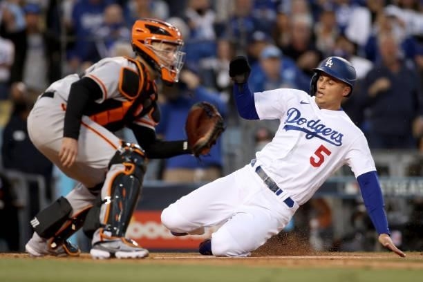 Corey Seager of the Los Angeles Dodgers scores against Buster Posey of the San Francisco Giants on a double by Trea Turner during the first inning in...