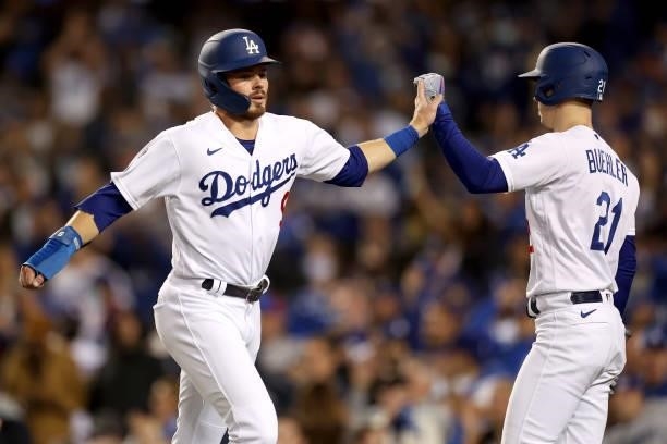 Gavin Lux celebrates his run with Walker Buehler of the Los Angeles Dodgers against the San Francisco Giants during the second inning in game 4 of...