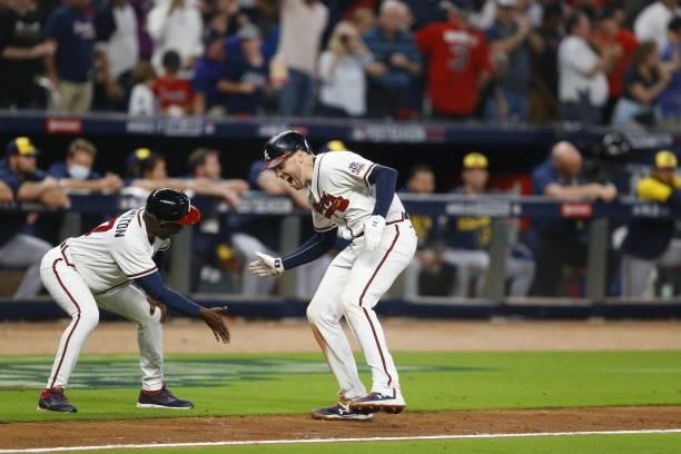 Freddie Freeman of the Atlanta Braves high fives Ron Washington during the eighth inning in game four of the National League Division Series against...