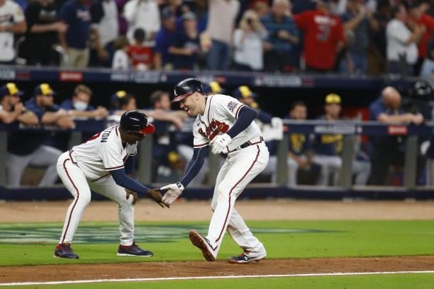 Freddie Freeman of the Atlanta Braves high fives Ron Washington during the eighth inning after hitting a home run in game four of the National League...