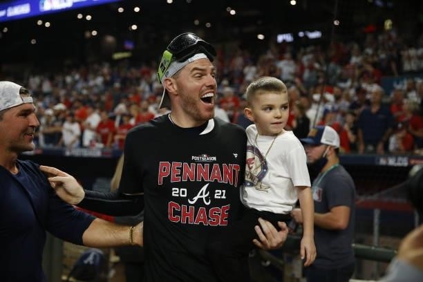 Freddie Freeman of the Atlanta Braves celebrates with his son Charlie following the win over the Milwaukee Brewers in game four of the National...