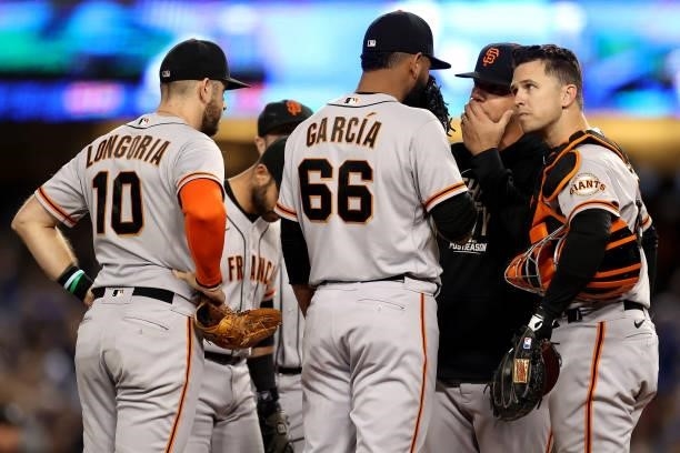Pitching coach Andrew Bailey talks with Jarlin Garcia of the San Francisco Giants during the third inning in game 4 of the National League Division...