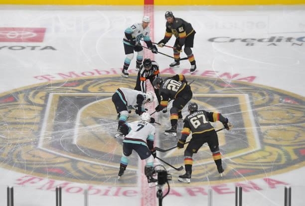 Chandler Stephenson of the Vegas Golden Knights faces off with Jared McCann of the Seattle Kraken to start their game at T-Mobile Arena on October...