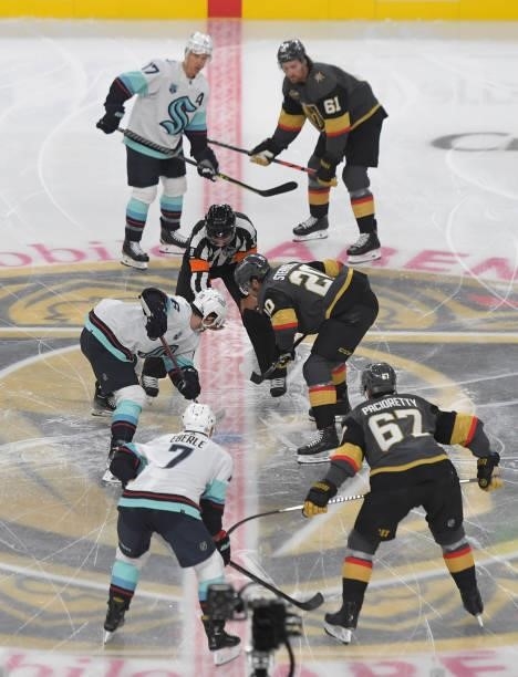 Chandler Stephenson of the Vegas Golden Knights faces off with Jared McCann of the Seattle Kraken to start their game at T-Mobile Arena on October...