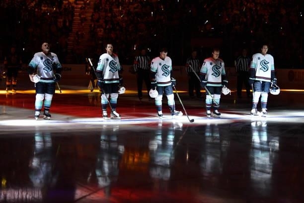 The Seattle Kraken stand on the ice for the national anthem prior to a game against the Vegas Golden Knights at T-Mobile Arena on October 12, 2021 in...