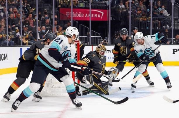 Alex Wennberg and Joonas Donskoi of the Seattle Kraken converge on Robin Lehner of the Vegas Golden Knights during the first period of the Kraken's...
