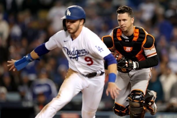 Buster Posey of the San Francisco Giants tags out Gavin Lux of the Los Angeles Dodgers during the fifth inning in game 4 of the National League...