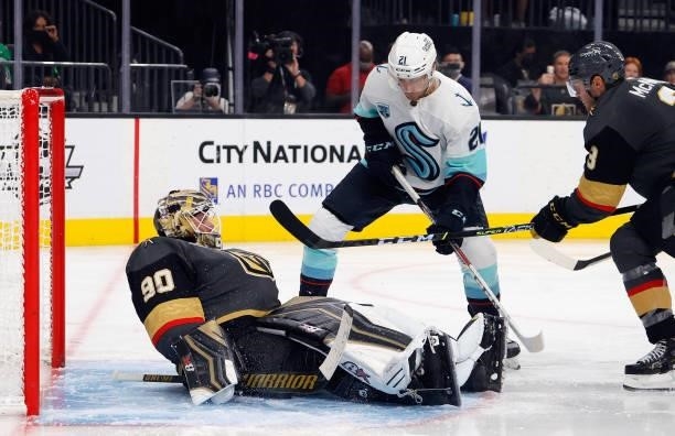 Robin Lehner of the Vegas Golden Knights covers the puck during the third period against Alex Wennberg of the Seattle Kraken of the Kraken's...
