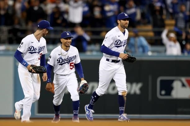 Chris Taylor, Cody Bellinger and Mookie Betts of the Los Angeles Dodgers react after beating the San Francisco Giants 7-2 in game 4 of the National...